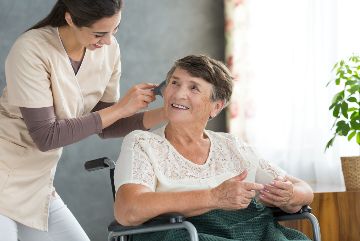 Energetic volunteer brushing pensioner's hair